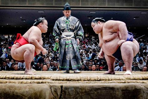 What do sumo wrestlers do to show the match is a religious ceremony, and why do they sometimes wear socks in the ring?