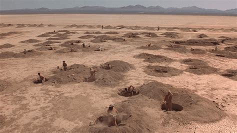 Where does the movie Holes take place, and how does its setting influence the narrative's surreal twists?